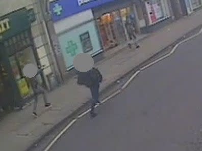 A CCTV still showing undercover armed police officers chasing Sudesh Amman, right, with their guns drawn after he stabbed two people in the Streatham attack (Metropolitan Police)