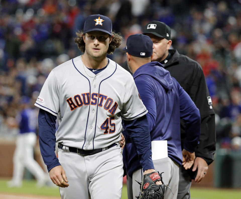 Houston Astros starting pitcher Gerrit Cole (45) walks away from bench coach Joe Espada, center, and umpire Ron Kulpa, rear, after working against the Texas Rangers in the seventh inning of a baseball game in Arlington, Texas, Wednesday, April 3, 2019. Cole had a heated discussion with Kulpa after getting the final out against the Rangers in the inning. (AP Photo/Tony Gutierrez)