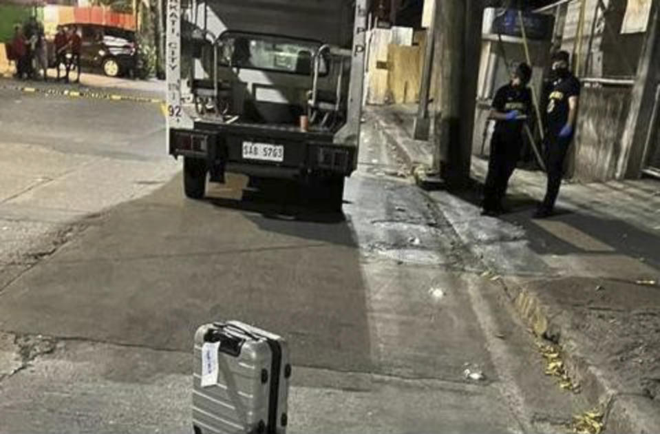 In this photo provided by the Public Information Office, National Capital Region Police Office shows investigators at the site where New Zealander Nicholas Peter Stacey was shot by suspected robbers in Makati, Philippines on Sunday Feb. 19, 2023. A massive Philippine police search was underway on Wednesday for two motorcycle-riding men who shot and killed the New Zealand man in a brazen street robbery that officials fear could scare foreign tourists away. (Public Information Office, National Capital Region Police Office via AP)