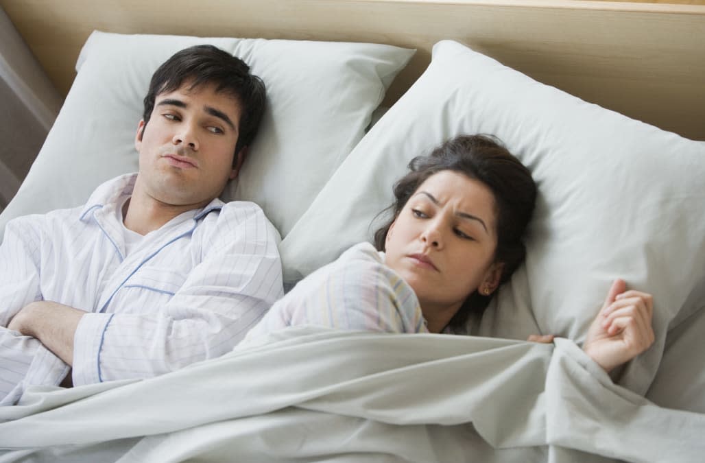 Couple looking angry in bed