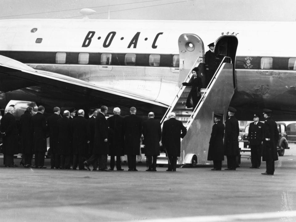 Queen Elizabeth II and Prince Philip, the Duke of Edinburgh, leaving their BOAC airliner as they return from Kenya following the death of King George VI and Elizabeth's accession to the throne on February 7, 1952