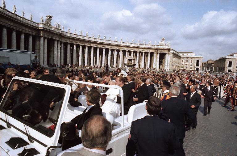 Pope John Paul II is helped by his bodyguards after being shot by Mehmet Ali Agca at St Peter's Square in Rome on May 13, 1981