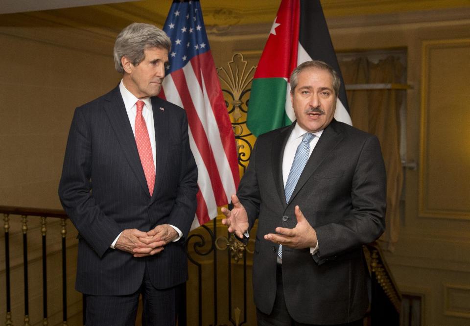 US Secretary of State John Kerry, left, looks on as Jordanian Foreign Minister Nasser Judeh makes a statement about the ongoing humanitarian crisis and violence in Syria on Wednesday, Feb. 19, 2014, in Paris. (AP Photo/ Evan Vucci)