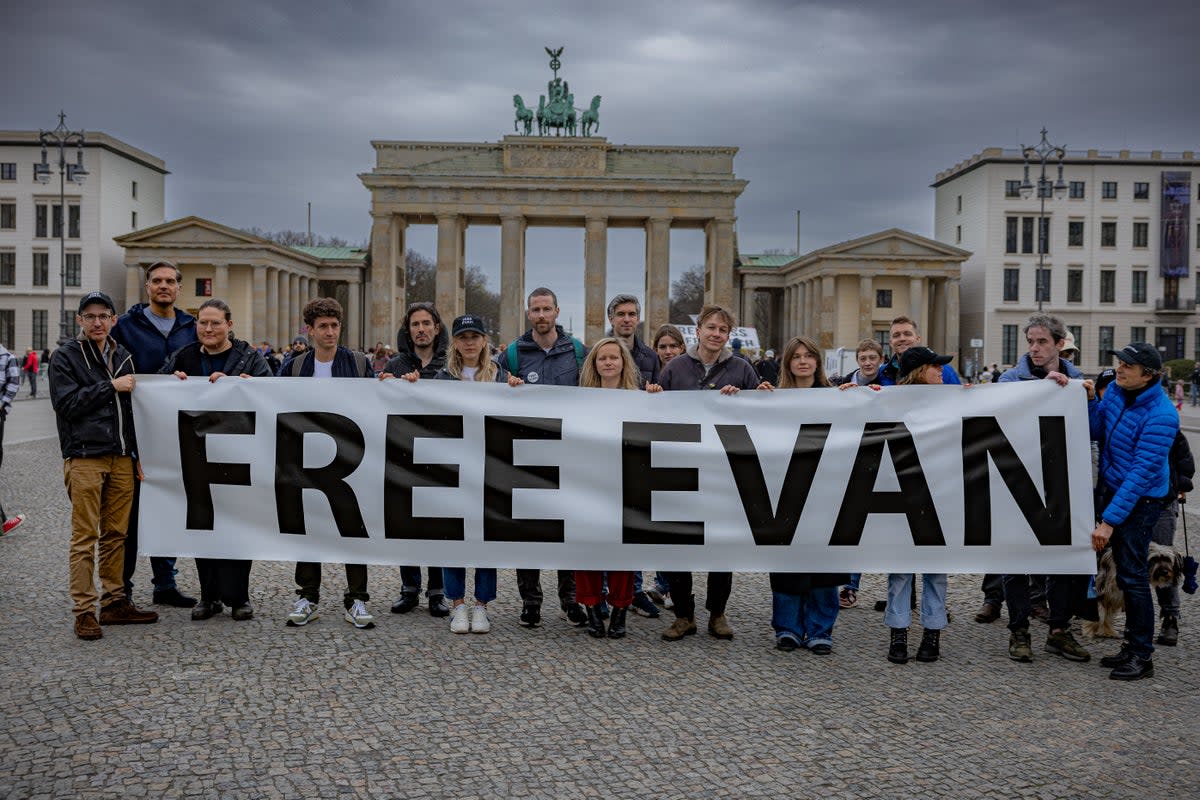 Supporters of Evan Gershkovich gather at Berlin’s Brandenburg Gate, near the Russian embassy, to call for his release on Friday  (Bel Trew)