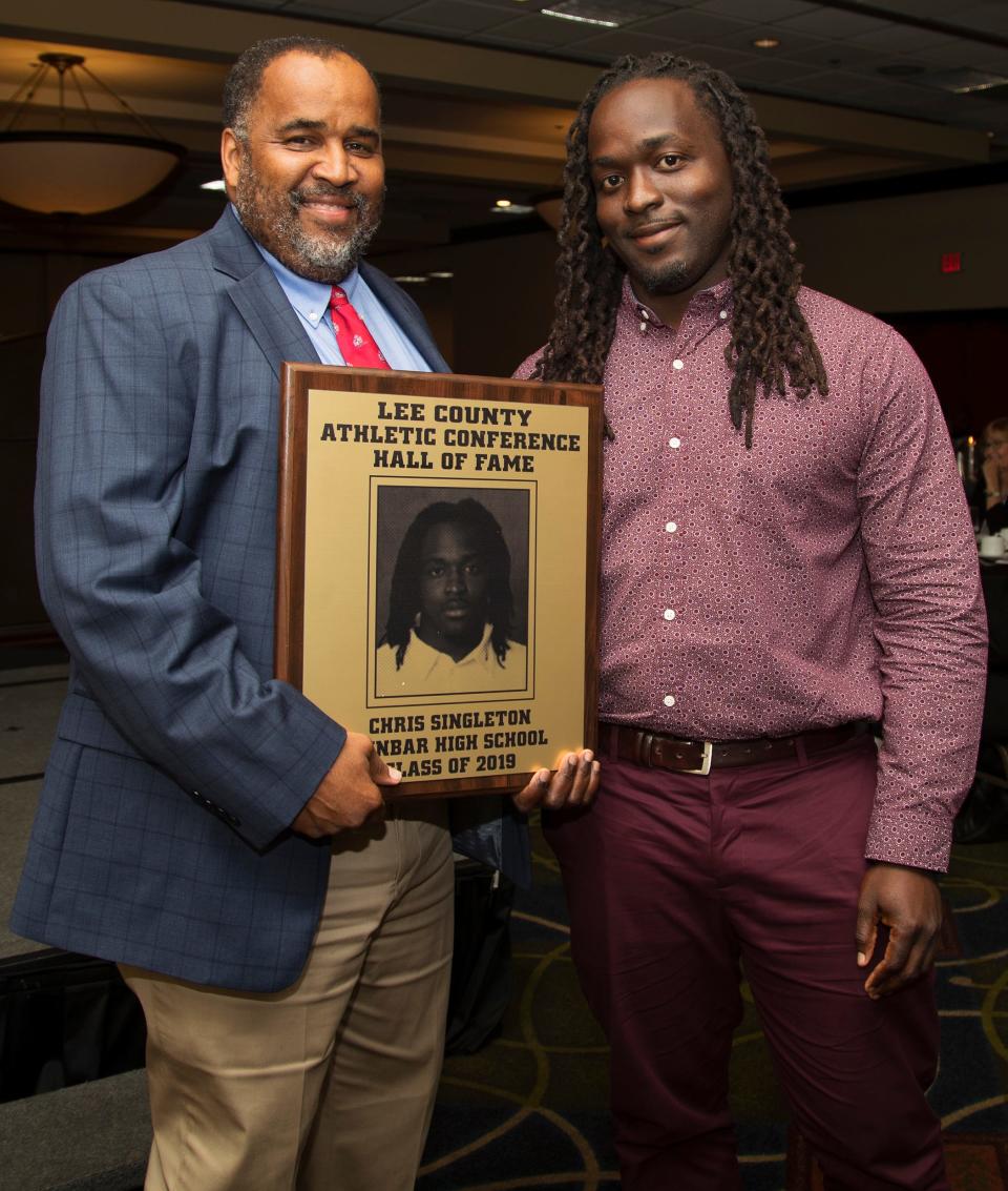 Chris Singleton, right, a 2005 Dunbar High School graduate, is inducted into the Lee County Athletic Conference Hall of Fame on Thursday in Fort Myers. Singleton played football at Dunbar. Singleton honored Dunbar High School principal Carl Burnside, left, in his acceptance speech.  