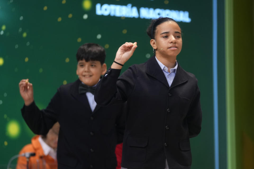 Children from Madrid's San Ildefonso school sing out the numbers from one of the main prizes from awarded lottery balls at Madrid's Teatro Real opera house during Spain's bumper Christmas lottery draw known as El Gordo, or The Fat One, in Madrid, Spain, Friday, Dec. 22, 2023. The lottery will shell out 400,000 euros ($440,000) to holders of 20-euro tickets bearing the top-prize number. The immensely popular lottery will distribute a total of 2.6 billion euros in prizes this year, much of it in small prizes. Street and bar celebrations normally break out with winners uncorking bottles of sparkling wine and singing and dancing. (AP Photo/Paul White)