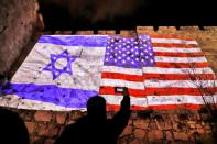 <p>A giant U.S. flag screened alongside Israel’s national flag by the Jerusalem municipality on the walls of the Old City. (Photo: Ahmad Gharabli/AFP/Getty Images) </p>