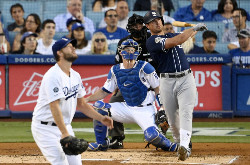 San Diego Padres' Hunter Renfroe watches his solo home run off Los Angeles Dodgers starting pitcher Clayton Kershaw, left, during the second inning of a baseball game Thursday, Aug. 1, 2019, in Los Angeles. At rear are catcher Will Smith and home plate umpire John Libka. (AP Photo/Mark J. Terrill)