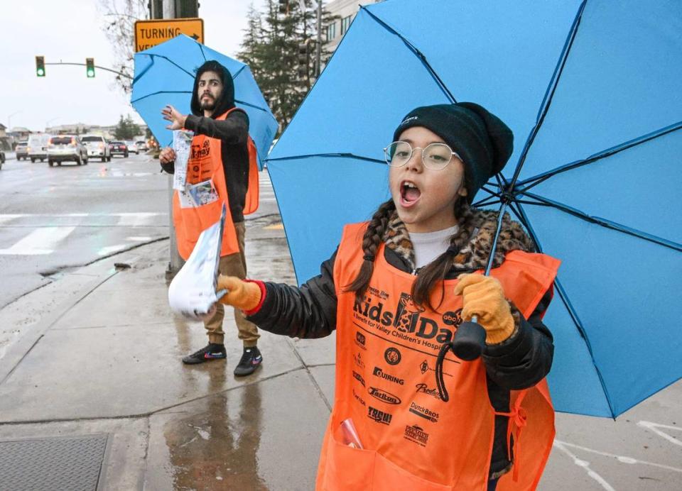 Penny Duarte, de 10 años, vende periódicos Kids Day con su padre Pete Duarte en la esquina de Friant y Audubon, en Fresno, el martes 12 de marzo de 2024. CRAIG KOHLRUSS/ckohlruss@fresnobee.com