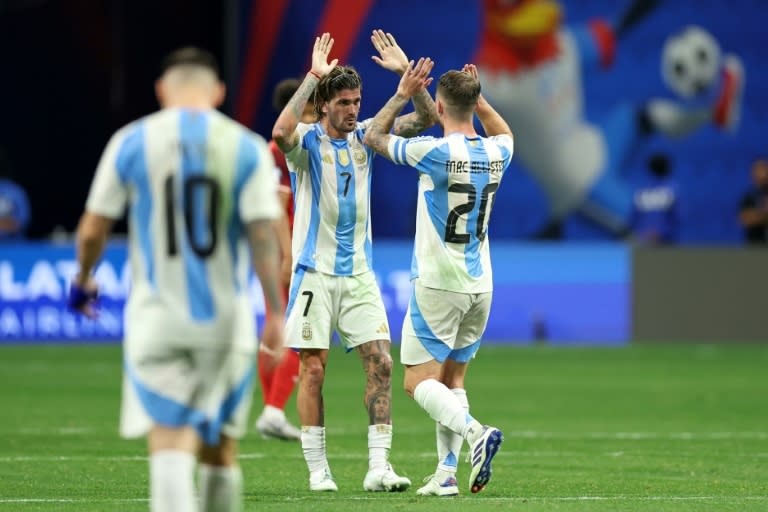 El mediocampista argentino #07 Rodrigo De Paul y el mediocampista argentino #20 Alexis Mac Allister celebran la victoria de su equipo al final del torneo de fútbol del grupo A de la Copa América Conmebol 2024 entre Argentina y Canadá en el estadio Mercedes Benz de Atlanta, Georgia, el 20 de junio. 2024. (CHARLY TRIBALLEAU)