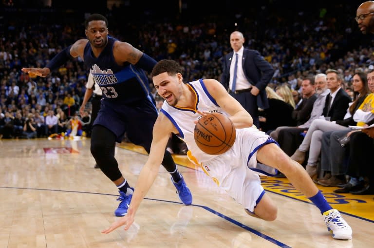 Klay Thompson of the Golden State Warriors slips while being guarded by Wesley Matthews of the Dallas Mavericks, at ORACLE Arena in Oakland, California, on January 27, 2016