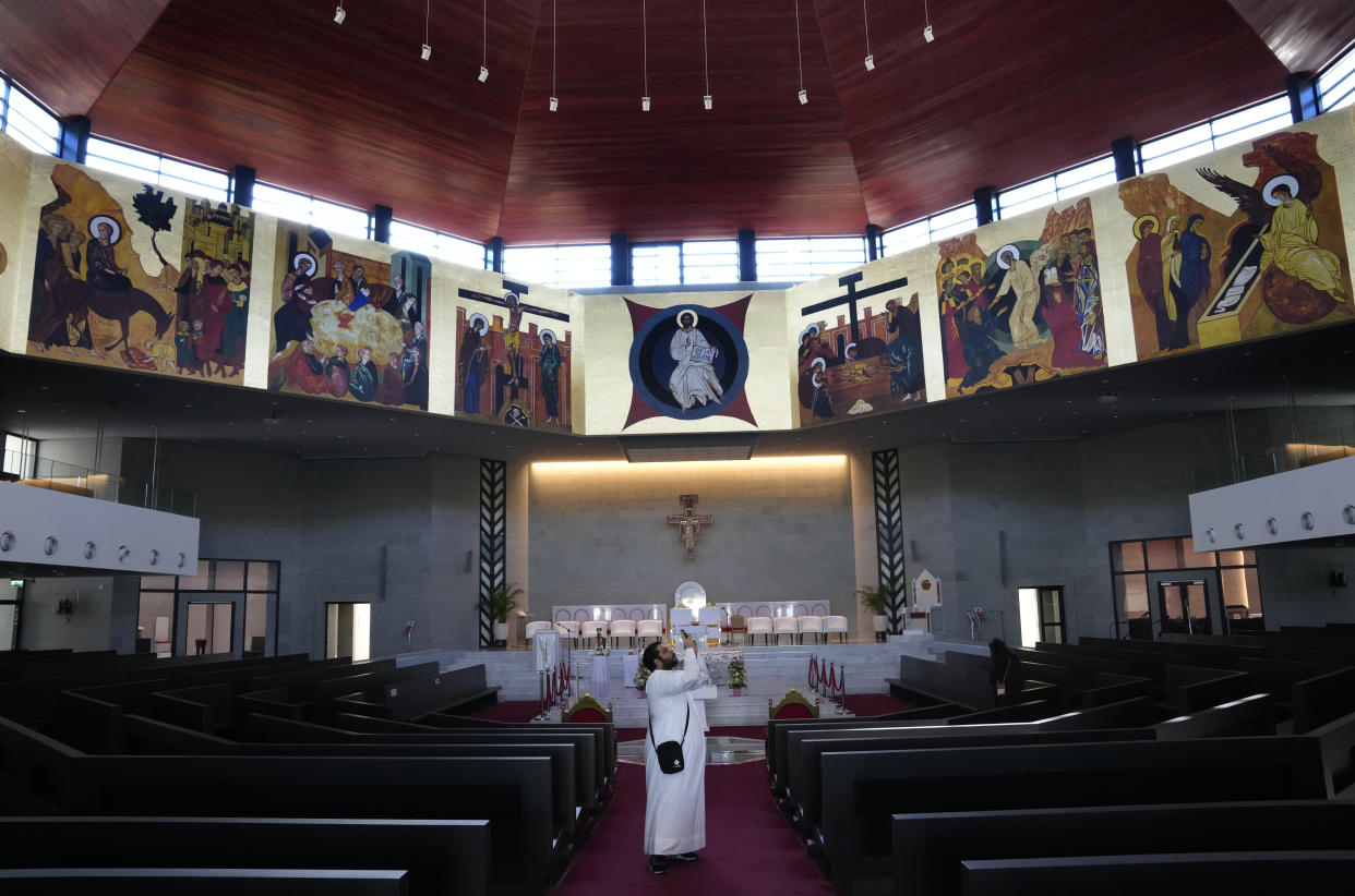 An Emirati journalist takes pictures by his mobile phone inside the Cathedral of Our Lady of Arabia where the Pope Francis will attend a Mass, in Manama, Bahrain, Wednesday, Nov. 2, 2022. Pope Francis is making the November 3-6 visit to participate in a government-sponsored conference on East-West dialogue and to minister to Bahrain's tiny Catholic community, part of his effort to pursue dialogue with the Muslim world. (AP Photo/Hussein Malla)