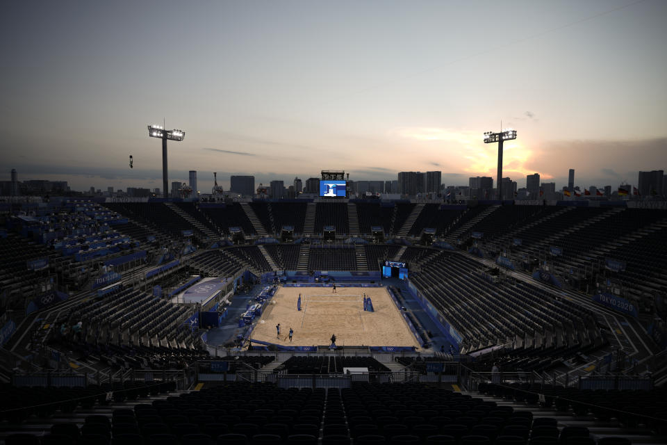 Volunteers clean up the sand after a beach volleyball match in the Shiokaze Park at the 2020 Summer Olympics, Sunday, July 25, 2021, in Tokyo, Japan. (AP Photo/Felipe Dana)