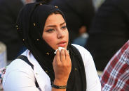 In this Tuesday, Sept. 18, 2018 photo, Hajar Youssif, an Iraqi activist and volunteer medic, who was kidnapped, beaten and threatened for attending protests, sits with protesters in Basra, Iraq. Youssif said the beating left her shaken and that threats continue, but she won’t be deterred. Activists say powerful Iranian-backed militias that control Iraq’s oil capital of Basra have waged a campaign of intimidation and arbitrary arrests to silence protests aimed at poor government services and Tehran’s outsized influence in the region. (AP Photo/Nabil al-Jurani)