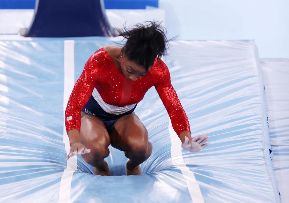 Biles is seen crouched down and leaning forward immediately after landing on the map
