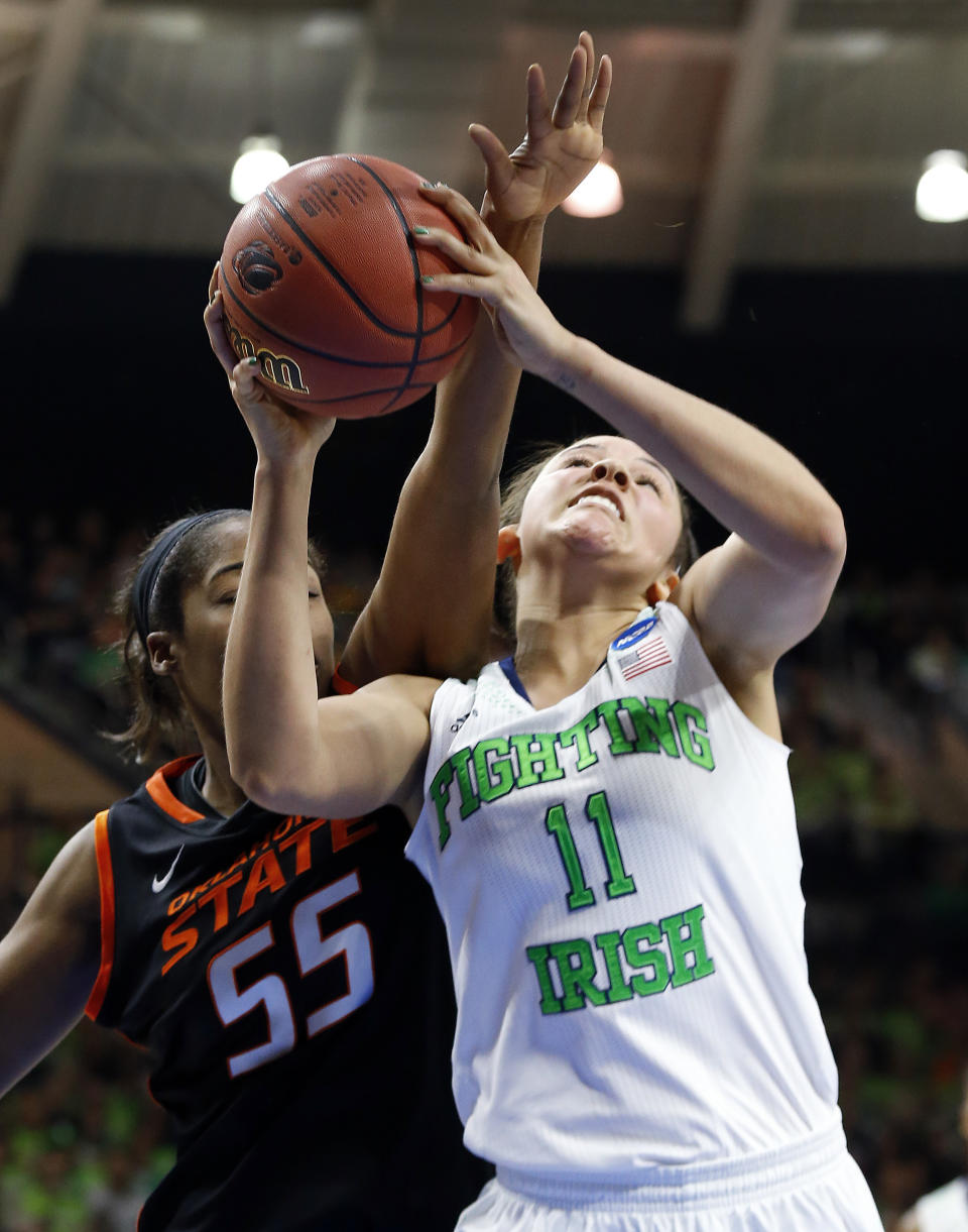 Notre Dame forward Natalie Achonwa (11) is fouled by Oklahoma State center LaShawn Jones (55) during the first half of a regional semifinal in the NCAA college basketball tournament at the Purcell Pavilion in South Bend, Ind., Saturday, March 29, 2014. (AP Photo/Paul Sancya)