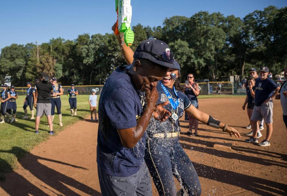 Central Catholic Raiders head coach Sam Nichols is splashed with water by infielder Jazmarie Roberts (3), after playing the Ponderosa Bruins in the CIF Northern California Division III softball championship game Saturday, June 3, 2023, at Ponderosa High School in Shingle Springs. The Raiders beat the Bruins, 7-0, for the NorCal title.