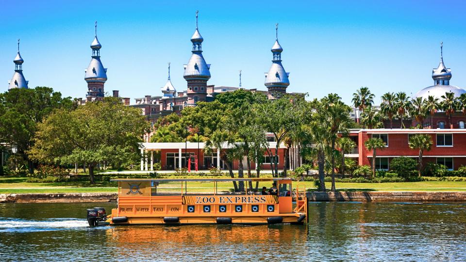 People on-board the Zoo Express water-taxi passes the University of Tampa, Florida.