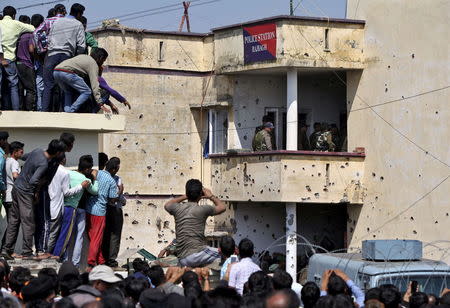 Onlookers look into the premises of a police camp after an attack at Kathua district, south of Jammu March 20, 2015. REUTERS/Mukesh Gupta