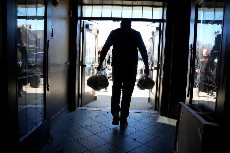 Mike Ensminger, a board member of Feed the Kids Columbus, carries bags of food out to a car to be delivered during a blessing bag packing event in Dublin.