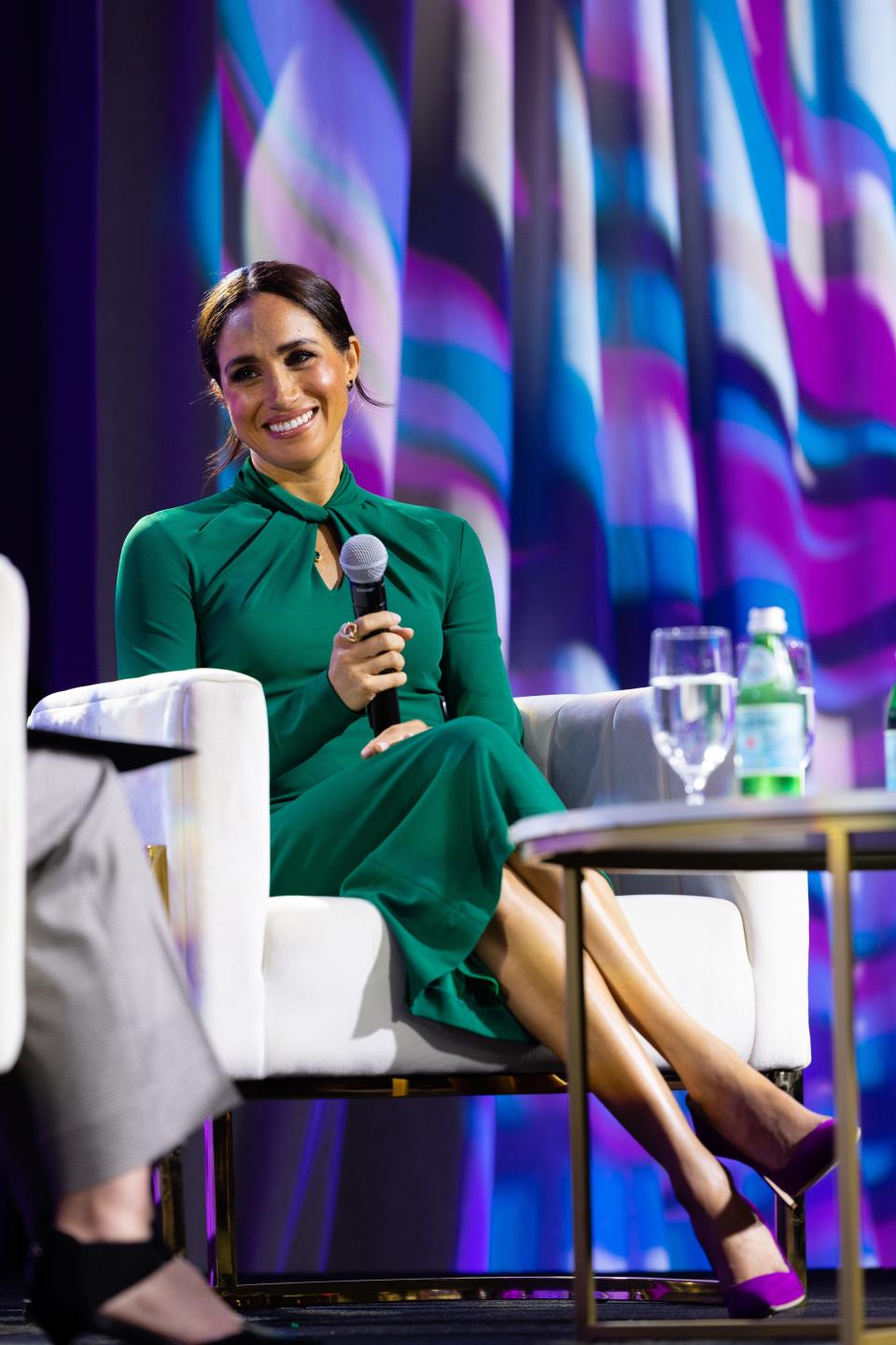 Meghan Markle wears a green Giorgio Armani dress with purple stilettos