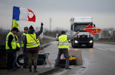 Protesters wearing yellow vests, the symbol of a French drivers' protest against higher diesel fuel prices, occupy a roundabout in Roppenheim, France, December 6, 2018. REUTERS/Vincent Kessler/Files