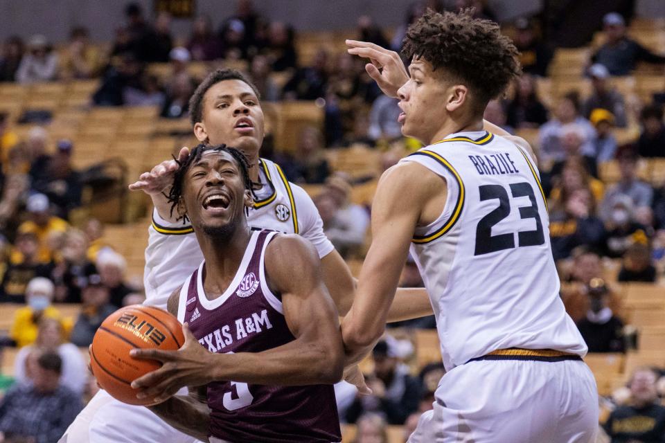 Texas A&M's Quenton Jackson, center, is defended by Missouri's Trevon Brazile, right, and Javon Pickett, back, during the first half of a game Saturday at Mizzou Arena.