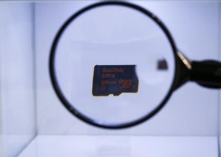 The new Sandisk ultra microSDXC memory card is seen through a magnifying glass during the Mobile World Congress in Barcelona March 3, 2015. REUTERS/Gustau Nacarino