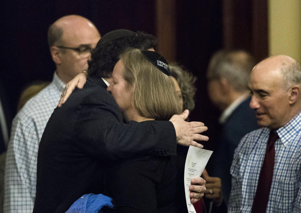 Dor Hadash Rabbi Cheryl Klein, center right, and New Light Rabbi Jonathan Perlman embrace after Pennsylvania lawmakers came together in an unusual joint session to commemorate the victims of the Pittsburgh synagogue attack that killed 11 people last year, Wednesday, April 10, 2019, at the state Capitol in Harrisburg, Pa. (AP Photo/Matt Rourke)