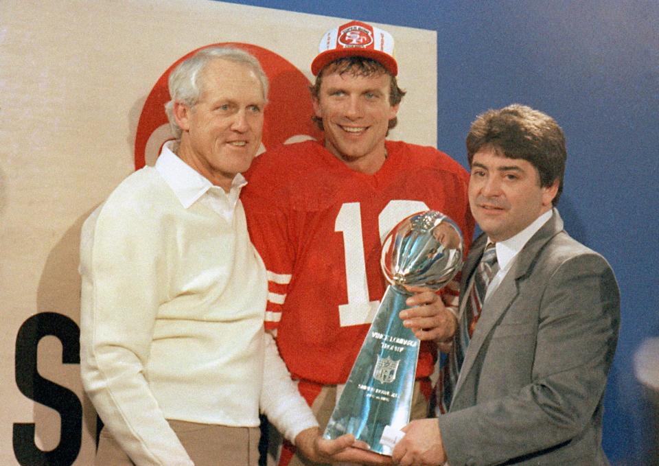 San Francisco 49ers quarterback Joe Montana, center, holds the Lombardi Trophy with coach Bill Walsh, left, and owner Edward DeBartolo, Jr., Jan. 20, 1985, in Stanford, Calif.