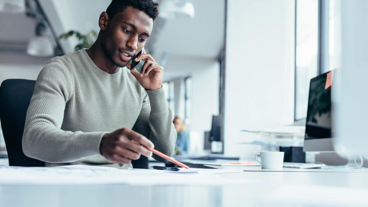 Businessman talking on smartphone and working in office.