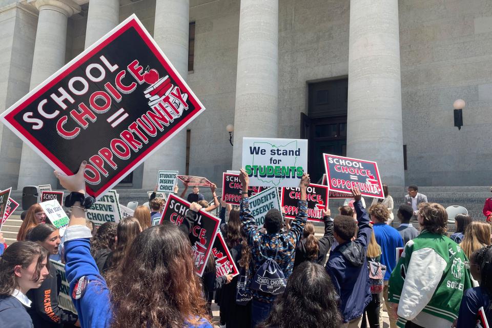 Students and parents rally at the Ohio Statehouse in support of possible changes that would increase eligibility for taxpayer-funded school vouchers to K-12 students statewide on Thursday, May 17, 2023, in Columbus, Ohio. Advocates applaud the changes as expanding school choice but opponents say such programs divert funding from public schools and violate Ohio's constitution. (AP Photo/Samantha Hendrickson)