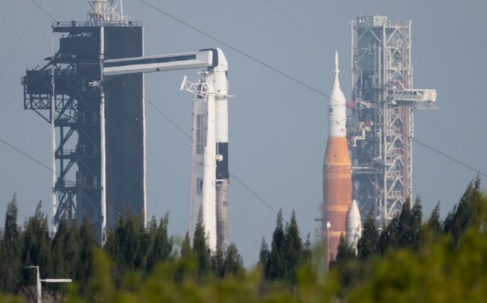 El Sistema de Lanzamiento Espacial de la NASA en la distancia y un Falcon9 de SpaceX en primer plano representan dos caras de los vuelos espaciales modernos: un proyecto grande y a largo plazo y un caballo de batalla pequeño, eficiente y reutilizable. <a href="https://www.flickr.com/photos/nasahqphoto/51986745354/" rel="nofollow noopener" target="_blank" data-ylk="slk:NASA/Joel Kowsky;elm:context_link;itc:0;sec:content-canvas" class="link ">NASA/Joel Kowsky</a>