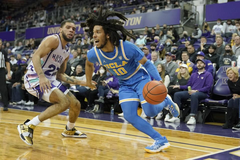 UCLA guard Tyger Campbell drives around Washington guard Terrell Brown Jr.