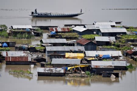Villagers use a boat as they row past partially submerged houses at a flood-affected village in Morigaon district in the northeastern state of Assam, India July 14, 2017. REUTERS/Anuwar Hazarika