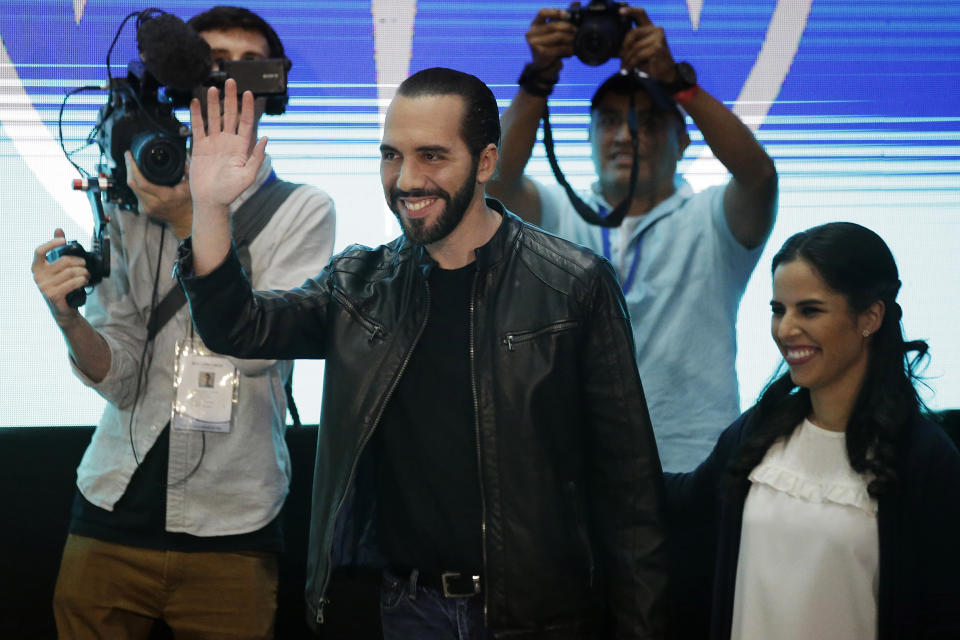 Presidential frontrunner Nayib Bukele, of the Grand Alliance for National Unity, waves while accompanied by his wife Gabriela before giving a press conference in San Salvador, El Salvador, Feb. 3, 2019. Bukele, a former mayor of El Salvador's capital, romped to victory in Sunday's presidential election, winning more votes than his two closest rivals combined to end a quarter century of two-party dominance in the crime-plagued Central America nation. (AP Photo/Moises Castillo)