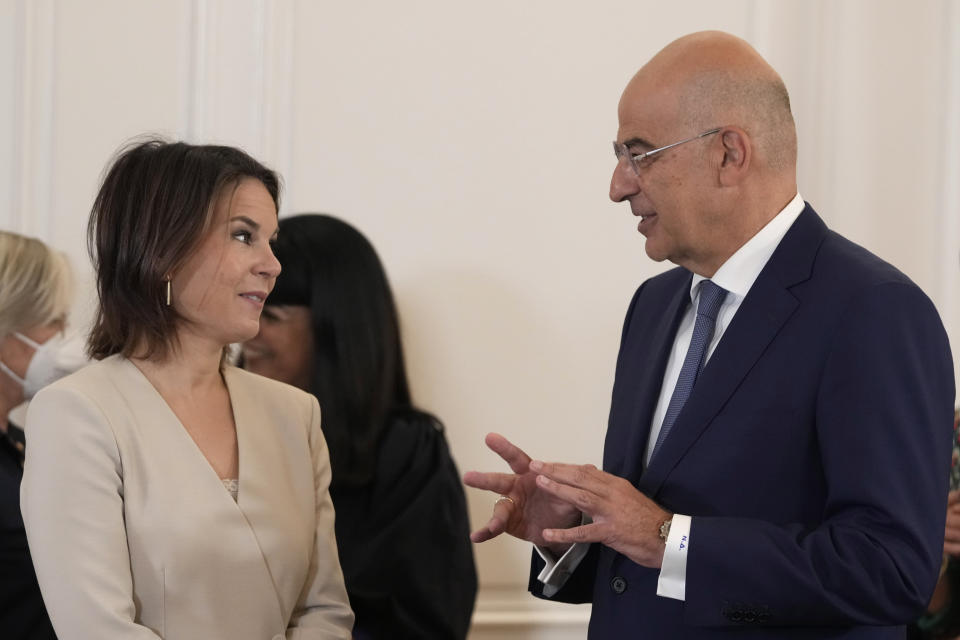 Greek foreign Minister Nikos Dendias, right, talks with the German Minister of Foreign Affairs Annalena Baerbock before the with Greek Prime Minister Kyriakos Mitsotakis, in Athens, on Friday, July 29, 2022. Baerbock is on a two-day official visit to Greece. (AP Photo/Petros Giannakouris)