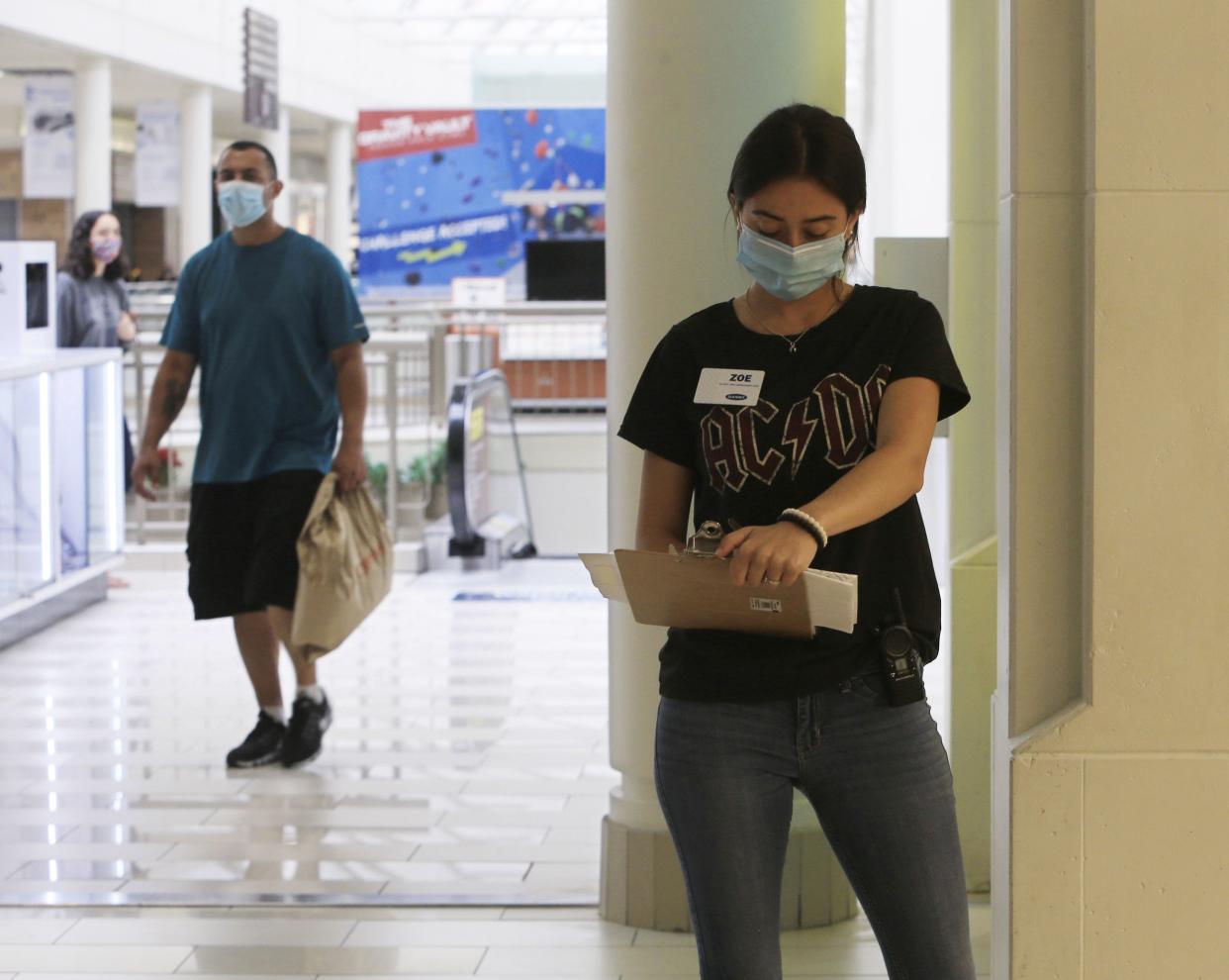 Employee Zoe Golden-Johnson records the number of shoppers who exit and enter the Old Navy store at the Poughkeepsie Galleria on July 10, 2020, in Poughkeepsie, New York. Certain regions in New York state were allowed to reopen on Friday after being shuttered due to the coronavirus. They are required to upgrade their ventilation systems and enforce social distancing to the greatest extent possible.