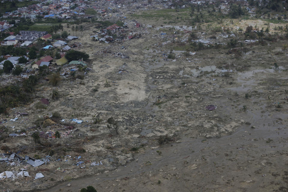 This Sunday, Oct. 7, 2018, an aerial photo covers part of the Petobo neighborhood wiped out by earthquake-triggered liquefaction in Palu, Central Sulawesi, Indonesia. Following the 7.5 magnitude earthquake on Sept. 28, the ground in the area simply lost its strength and turned to mush beneath people's feet, creating mud that acted like quicksand. Humans, houses, cars, and streets were sucked down and covered by a thick carpet of what _ just seconds earlier _ had been solid earth. (AP Photo/Dita Alangkara)