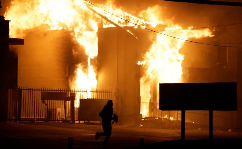 A man runs away from the burning storage facility. Picture: AP