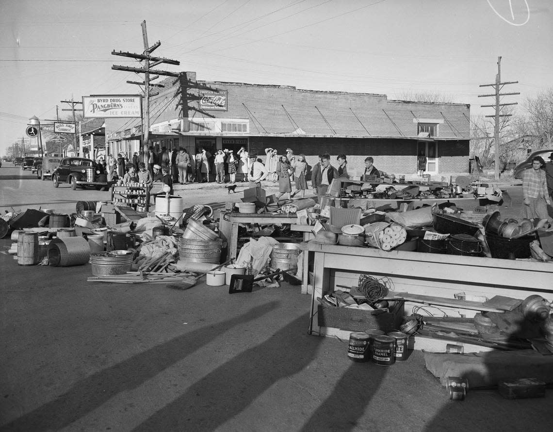 Dec. 5, 1941: Residents of Keller turned firefighters when a grass fire started a blaze that destroyed a lumber yard, beauty shop and hardware store. While they waited for a water hose to be brought from Roanoke, Texas, seven miles away, the volunteer firemen removed merchandise from the hardware store. Behind them is a line of people at Byrd Drug Store. Fort Worth Star-Telegram archive/UT Arlington Special Collections