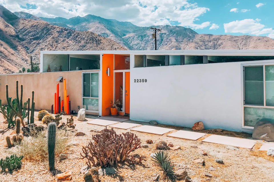 Mid-century modern house in desert with orange door. 