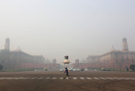 A man crosses a road next to Indian Defence Ministry and Home Ministry buildings on a smoggy morning in New Delhi, India, November 5, 2018. REUTERS/Altaf Hussain