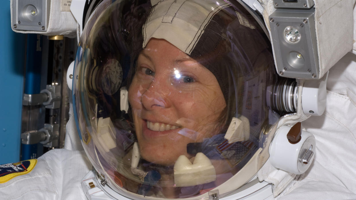  A close up of a human in a spacesuit, smiling. 