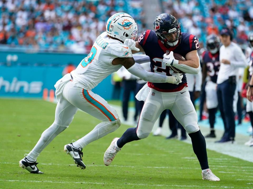 Rex Burkhead fights off a defender against the Miami Dolphins.