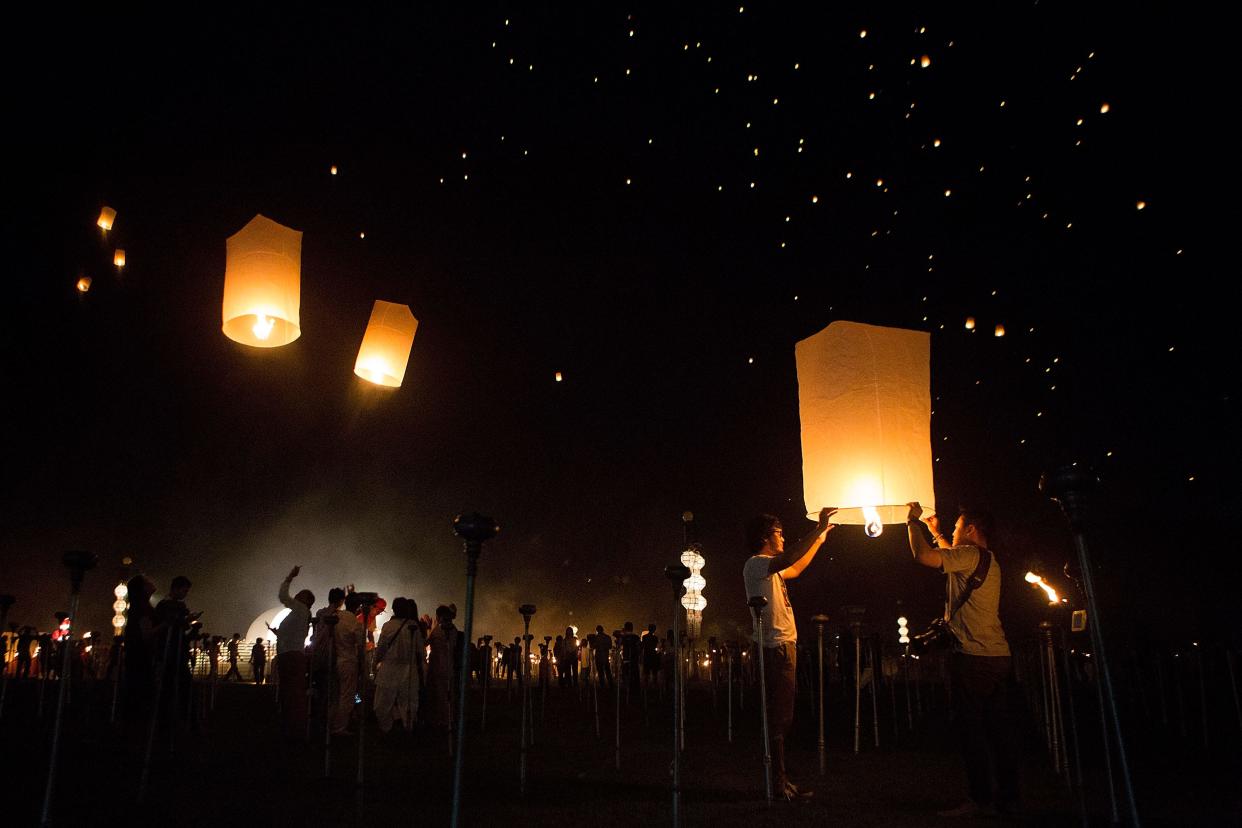 Tourists and Thai locals gather to release paper lanterns at the Lanna Dhutanka Temple in Chiang Mai, Thailand. The Lanna Kathina Ceremony takes place around the Loy Krathong and Yi Peng holidays each year and marks the end of Buddhist lent, when monks are offered new robes. 