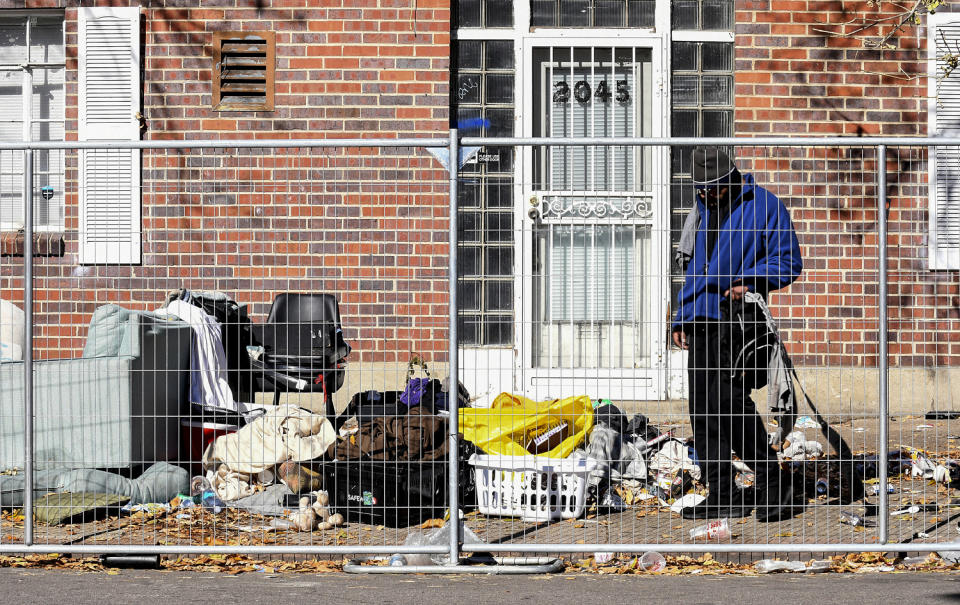 A homeless man sifts through his belongings during a sweep of an encampment in downtown Denver  (Thomas Peipert / AP file)