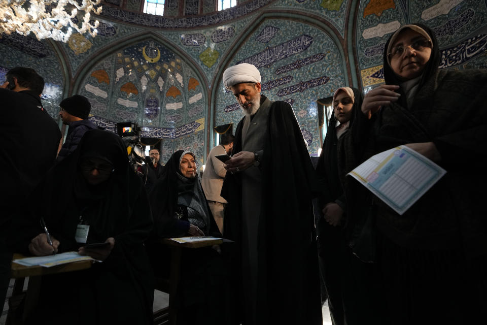 A cleric fills out his ballot during the parliamentary and Assembly of Experts elections at a polling station in Tehran, Iran, Friday, March 1, 2024. Iran began voting Friday in its first elections since the mass 2022 protests over its mandatory hijab laws after the death of Mahsa Amini, with questions looming over just how many people will turn out for the poll. (AP Photo/Vahid Salemi)