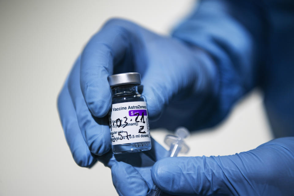 A health worker holds up a vial of the AstraZeneca vaccine for COVID-19 at a vaccination center set up at the Allianz Stadium in Turin, northern Italy, Wednesday, March 24, 2021. Italian Government officials said on Wednesday doses of AstraZeneca vaccine at a packaging plant in central Italy were destined for Belgium, a statement that appeared to refute reports that the 29 million “hidden doses” were planned for export to Britain. (Fabio Ferrari/LaPresse via AP)