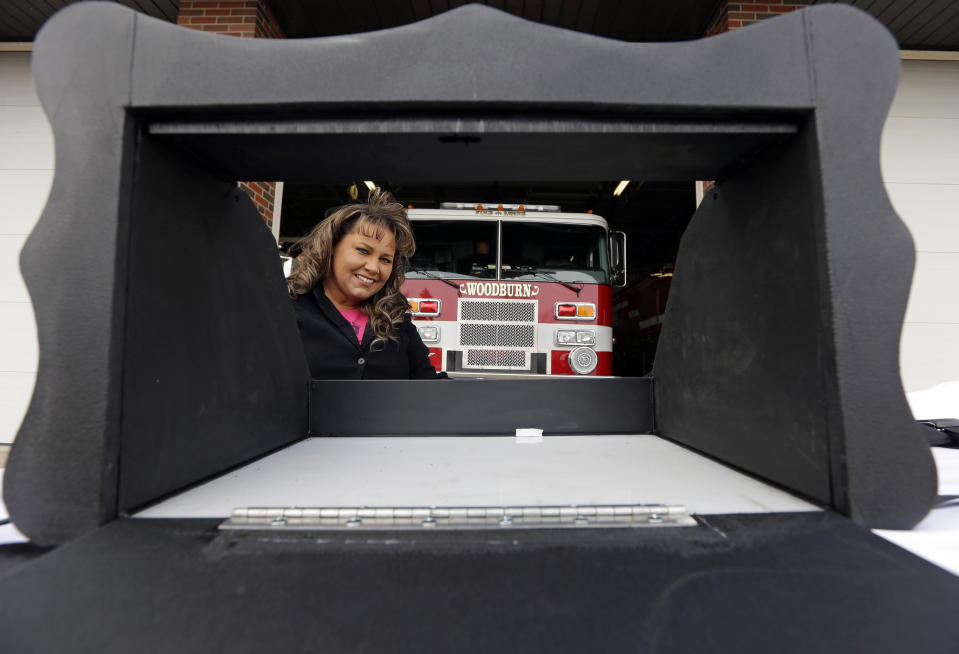 FILE - Monica Kelsey, firefighter and medic who is president of Safe Haven Baby Boxes Inc., poses with a prototype of a baby box, where parents could surrender their newborns anonymously, outside her fire station on Feb. 26, 2015, in Woodburn, Ind. A fight is developing in Florida's legislature over a measure that would allow fire stations and hospitals to install boxes where distressed mothers could leave their unwanted newborns. The Indiana-based group Safe Haven Baby Boxes is pushing the measure. It passed the House recently and is now before the Senate, where there is an attempt to block it.(AP Photo/Michael Conroy, File)